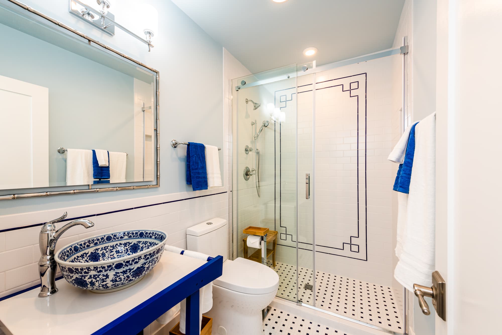 Bathroom has a vessel sink and a hand held shower in shower with glass doors